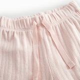 Red polka-dot baby pants with elastic and a decorative band at the waist.