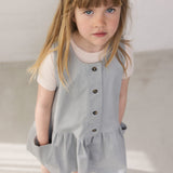 Wearing a buttonless blue chino dress with buttons and a bright red t-shirt.