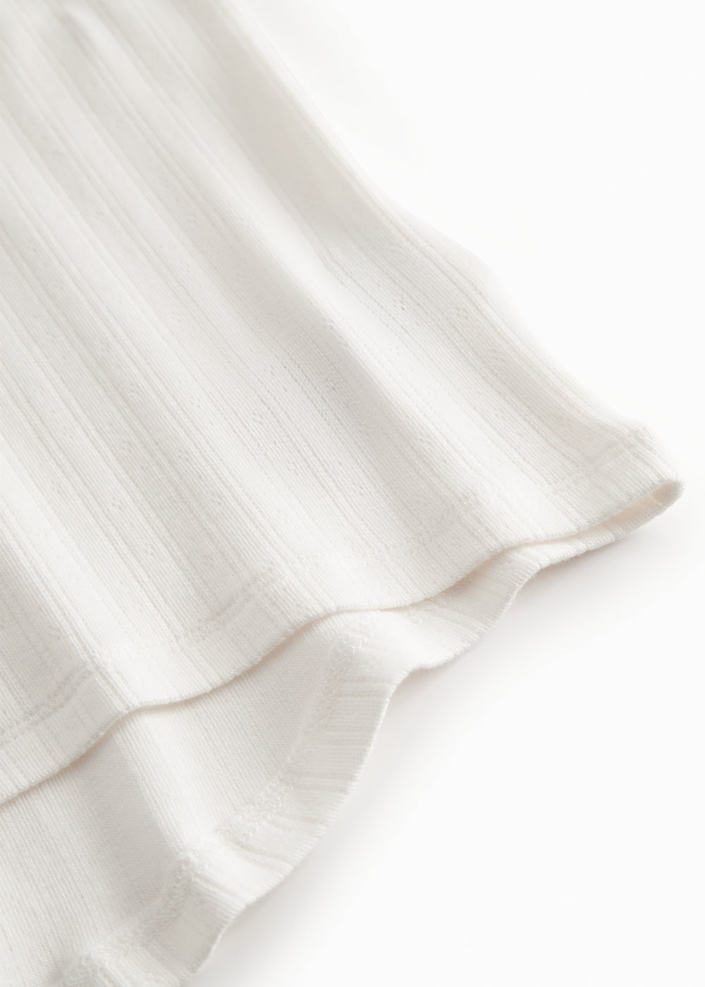 Short-sleeved white polka dot t-shirt for children with cuffs on the sleeves.