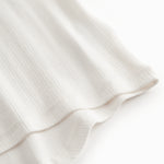 Short-sleeved white polka dot t-shirt for children with cuffs on the sleeves.