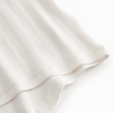 Short-sleeved white polka dot t-shirt for children with cuffs on the sleeves.