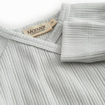 Light green pointelle blouse for newborns with a wrap-around closure.