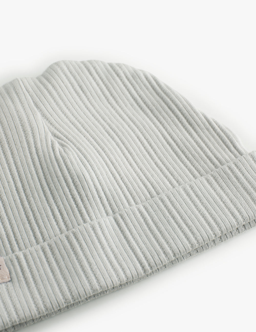 The baby hat in light green with a folded edge.