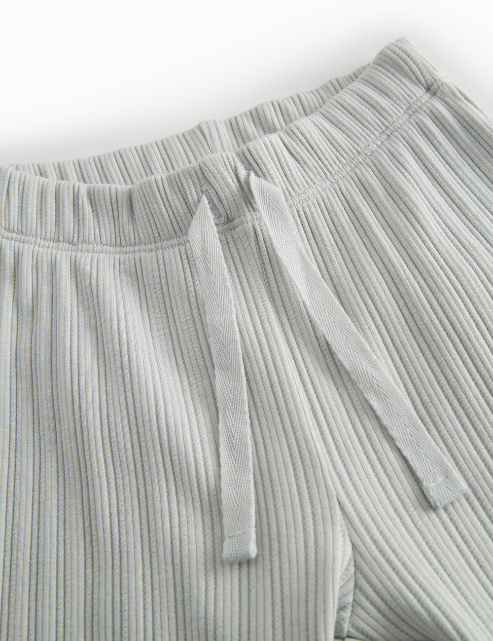 Green polka-dot baby pants with elastic and a decorative band at the waist.