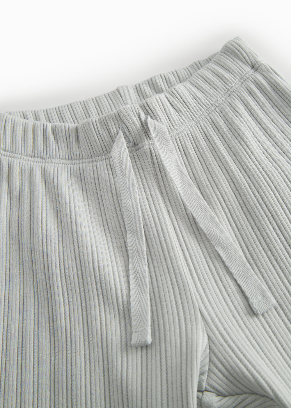 Green polka-dot baby pants with elastic and a decorative band at the waist.