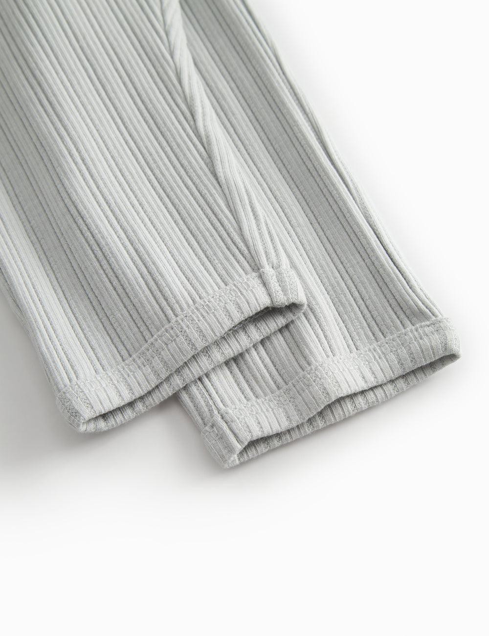 Green polka-dot baby pants with elastic and a decorative band at the waist.