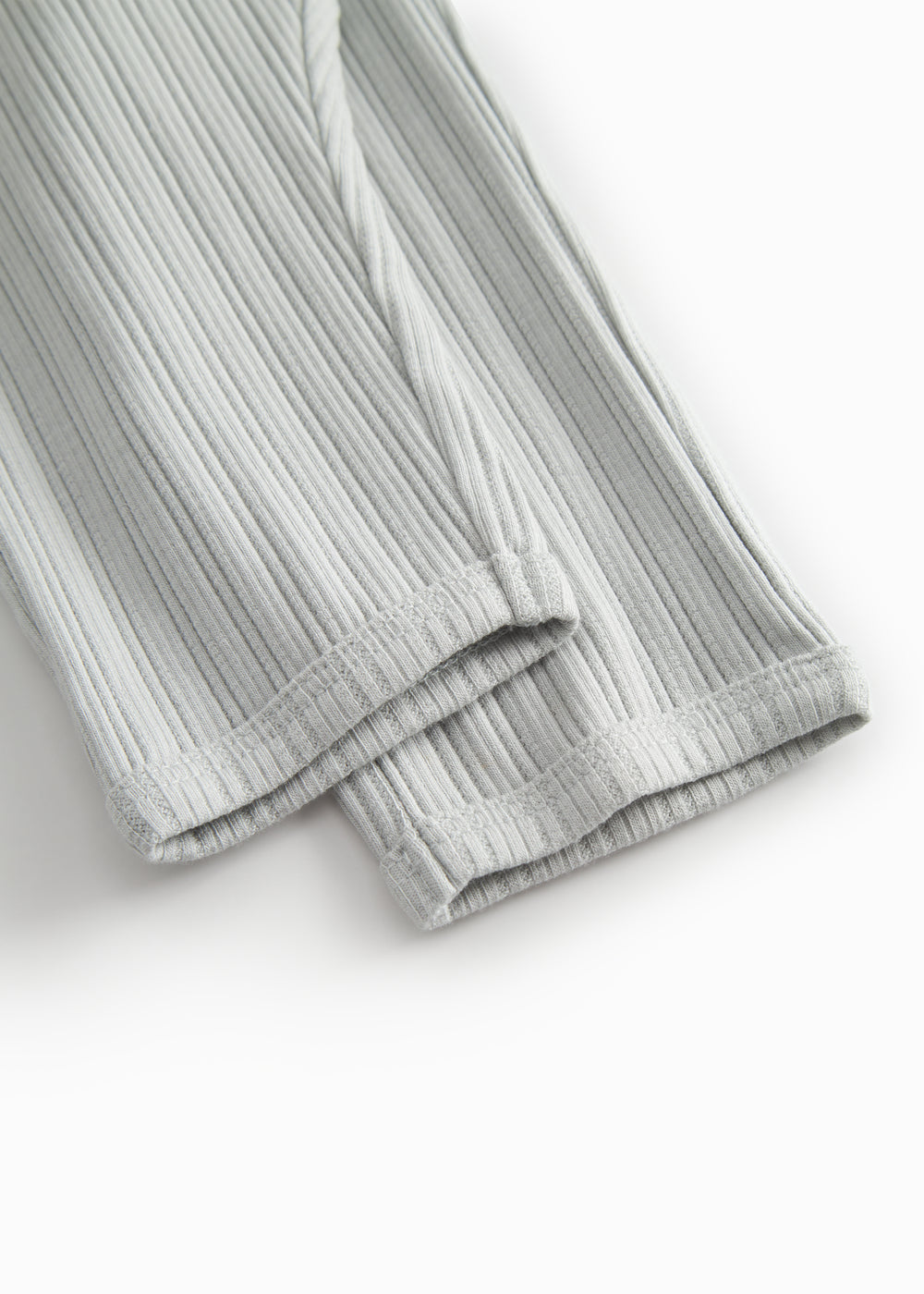 Green polka-dot baby pants with elastic and a decorative band at the waist.