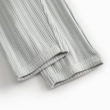 Green polka-dot baby pants with elastic and a decorative band at the waist.