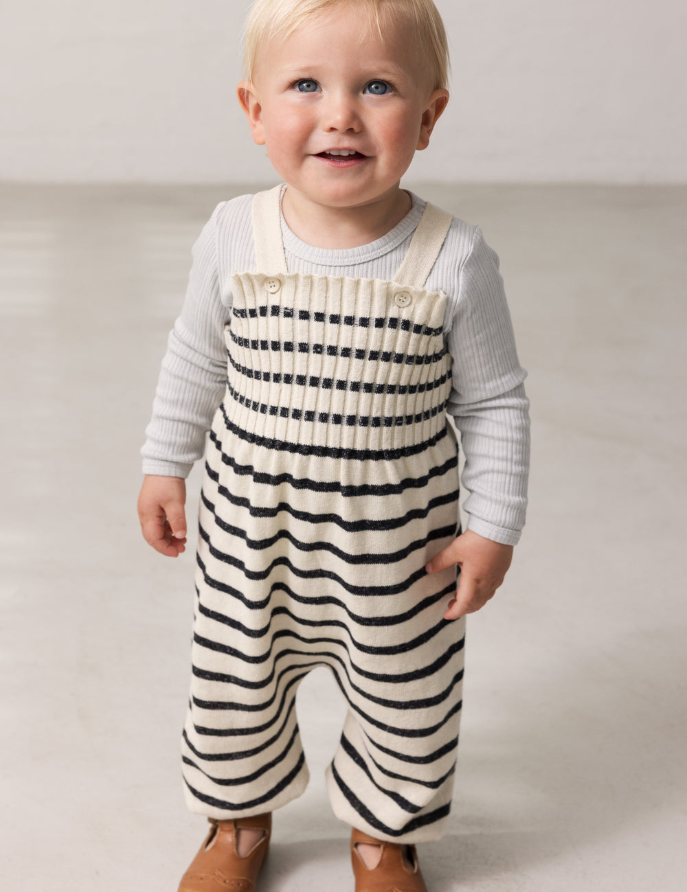Children wearing striped sweater vests for babies with sleeves.