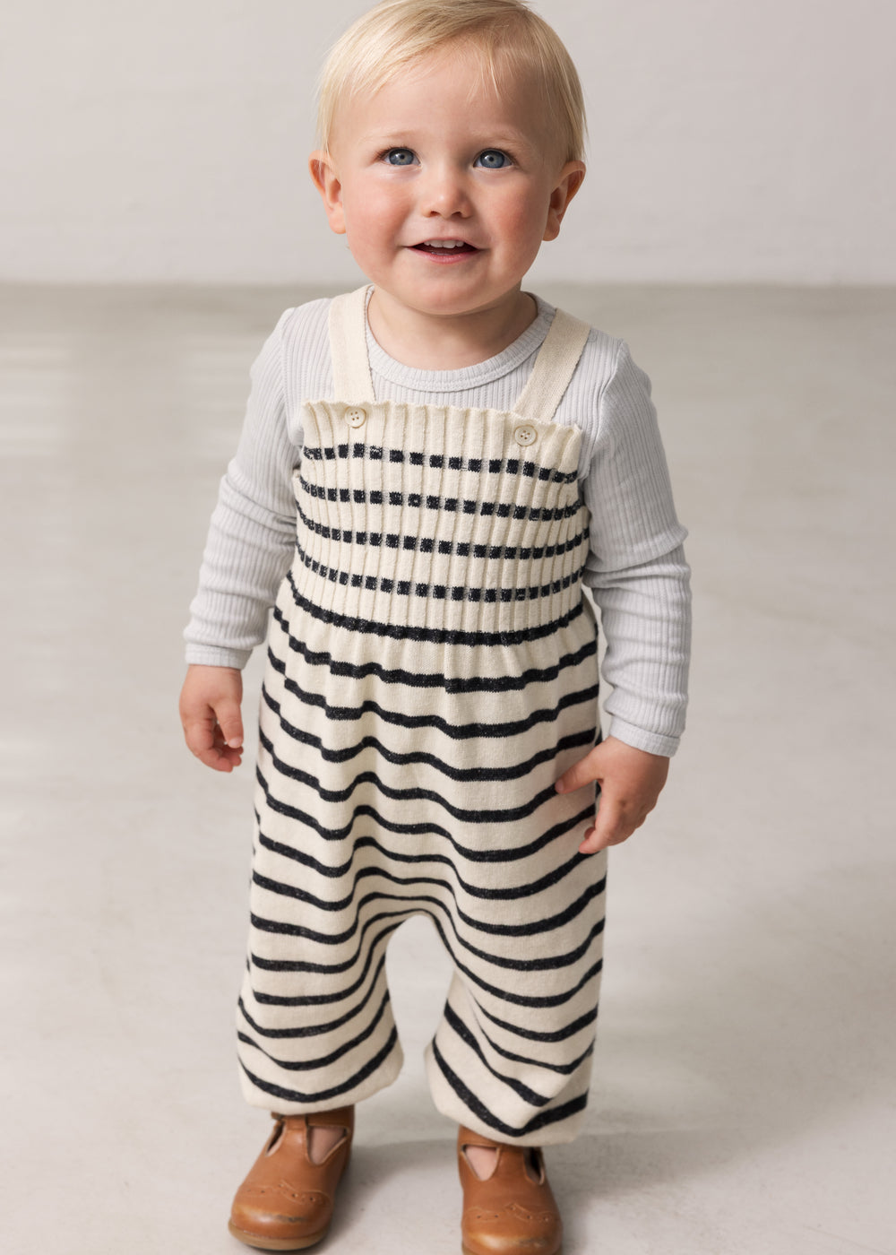 Children wearing striped sweater vests for babies with sleeves.