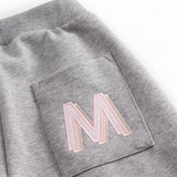 Gray sweatpants for children with a pink MarMar logo on the pocket and drawstring.