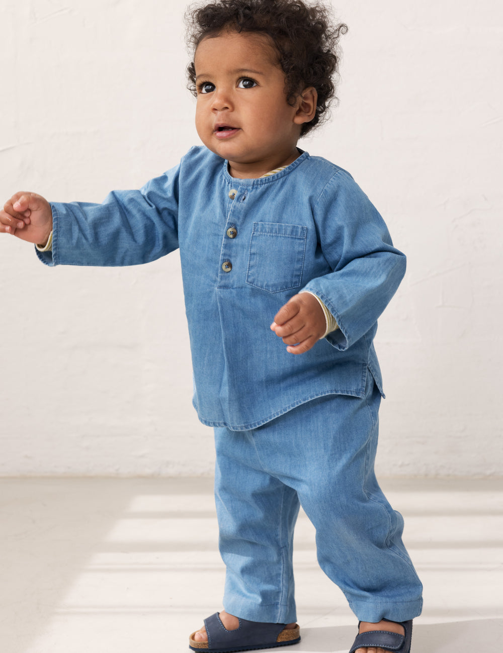 Baby wearing a long-sleeved denim shirt and jeans.