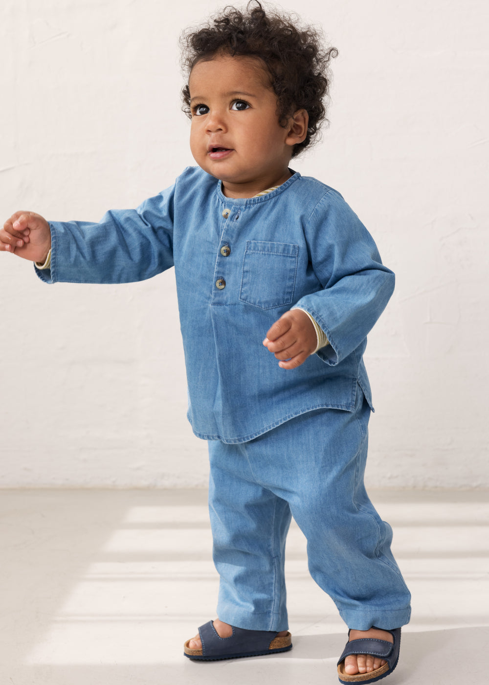 Baby wearing a long-sleeved denim shirt and jeans.