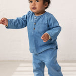 Baby wearing a long-sleeved denim shirt and jeans.