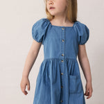 Child wearing a blue dress with short puffed sleeves.