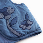 Blue denim vest for children with embroidered flowers.
