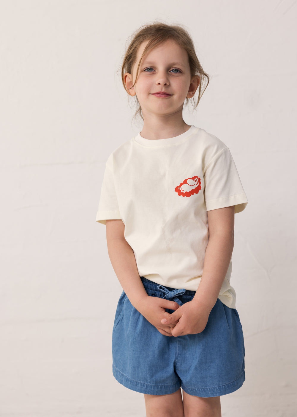 Child wearing a T-shirt and blue denim shorts