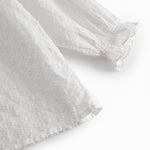 White baby bodysuit with a patterned design and collar