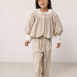 Children wearing a bright outfit with pants and a shirt.