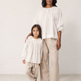 Woman and child wearing matching light outfits