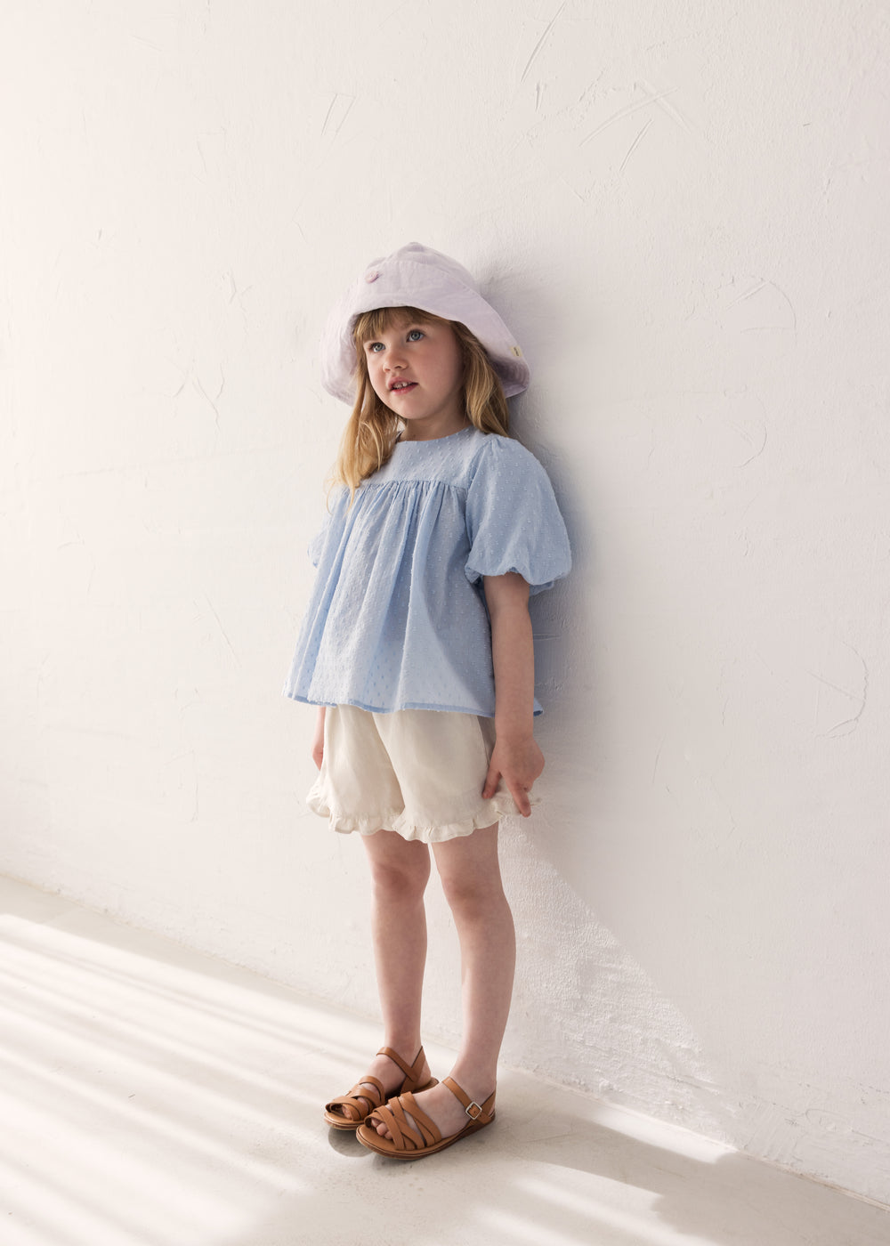 Children dressed in summer hats and bright outfits.