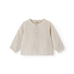 Sleeveless beige top for baby with ruffle details.