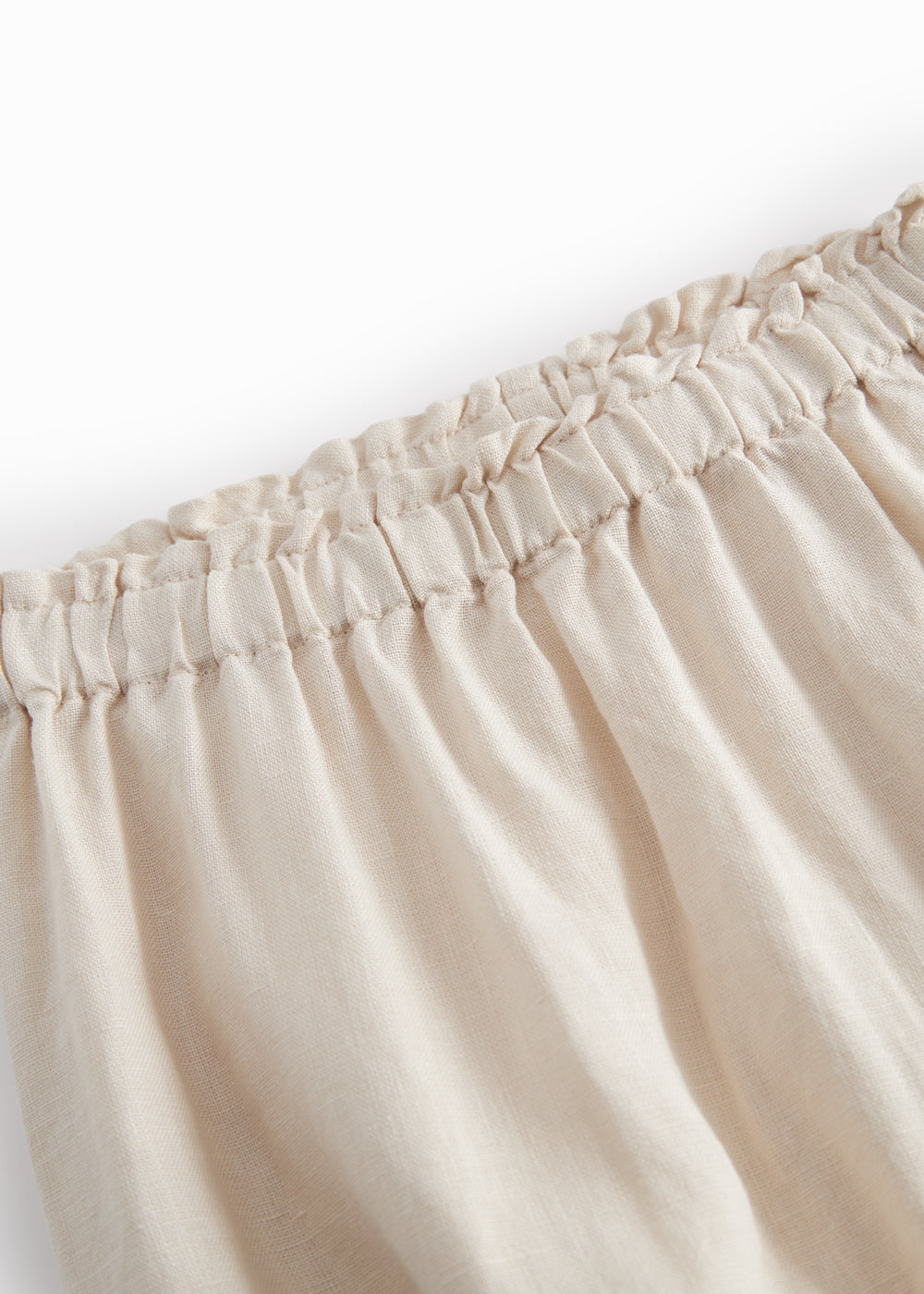 Beige pants for baby with loose fit and elastic in the waist.