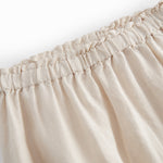 Beige pants for baby with loose fit and elastic in the waist.