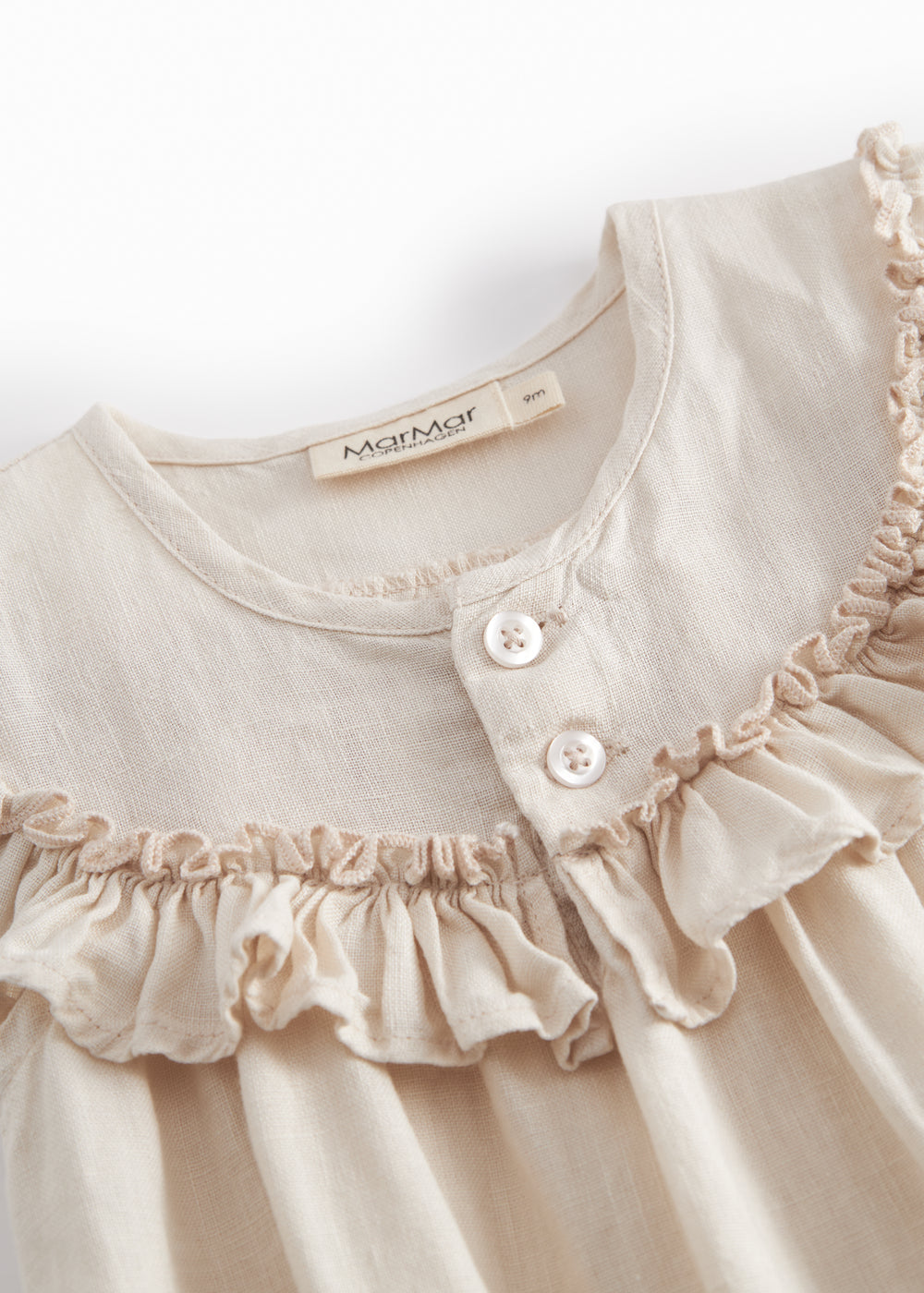 Beige heldragt baby baby with short sleeves and fl details.