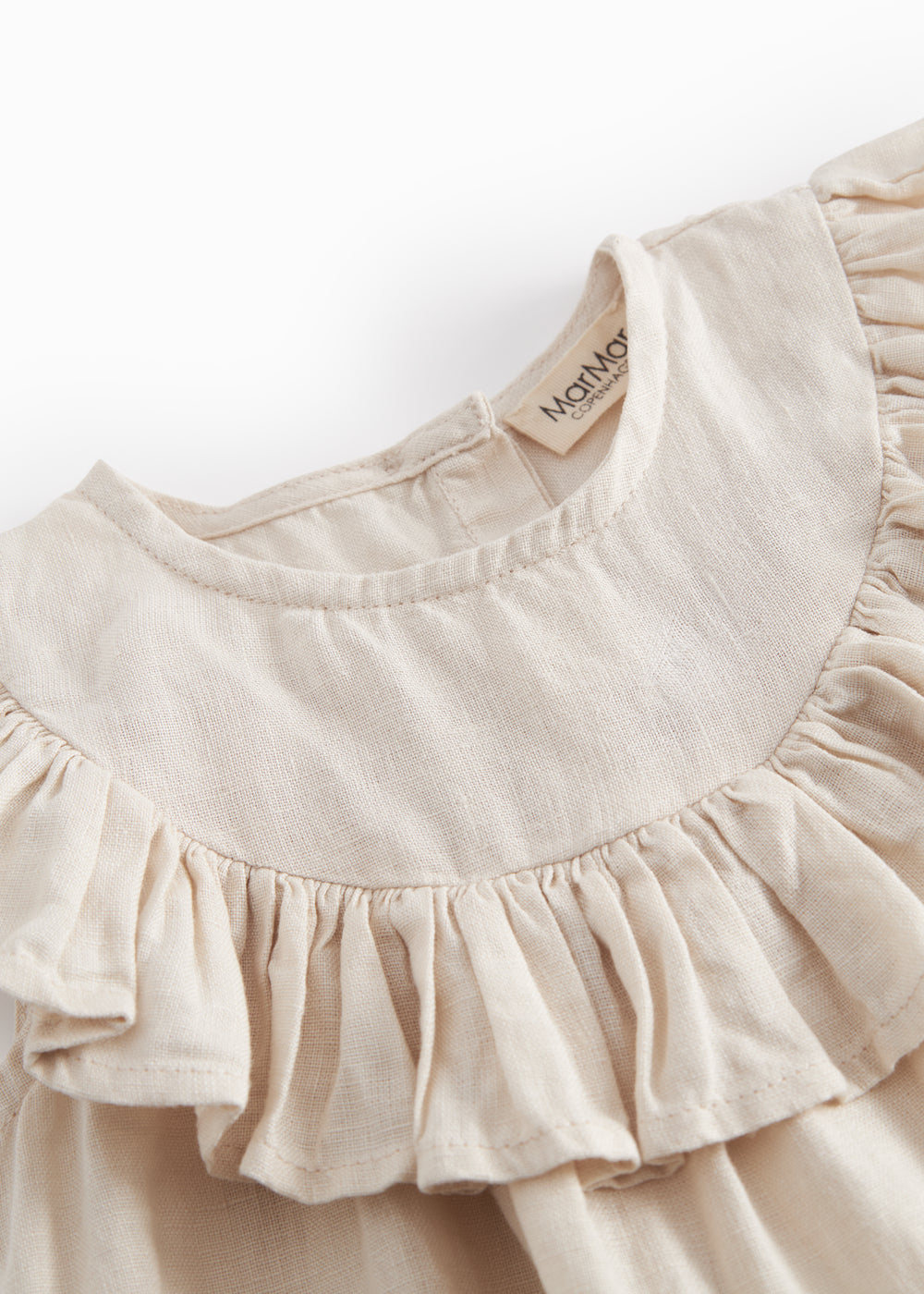 Ærmeløs beige top til baby med flæsedetaljer