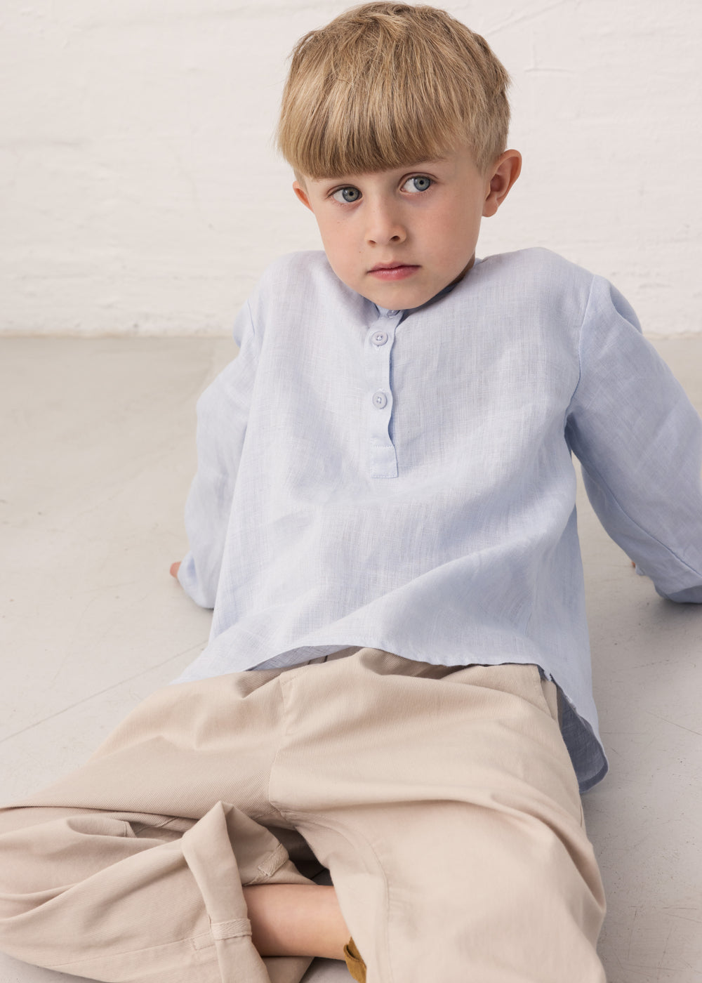 Boy in a light blue shirt and beige pants