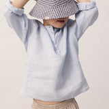 Boy with a light blue shirt and a hat on his head