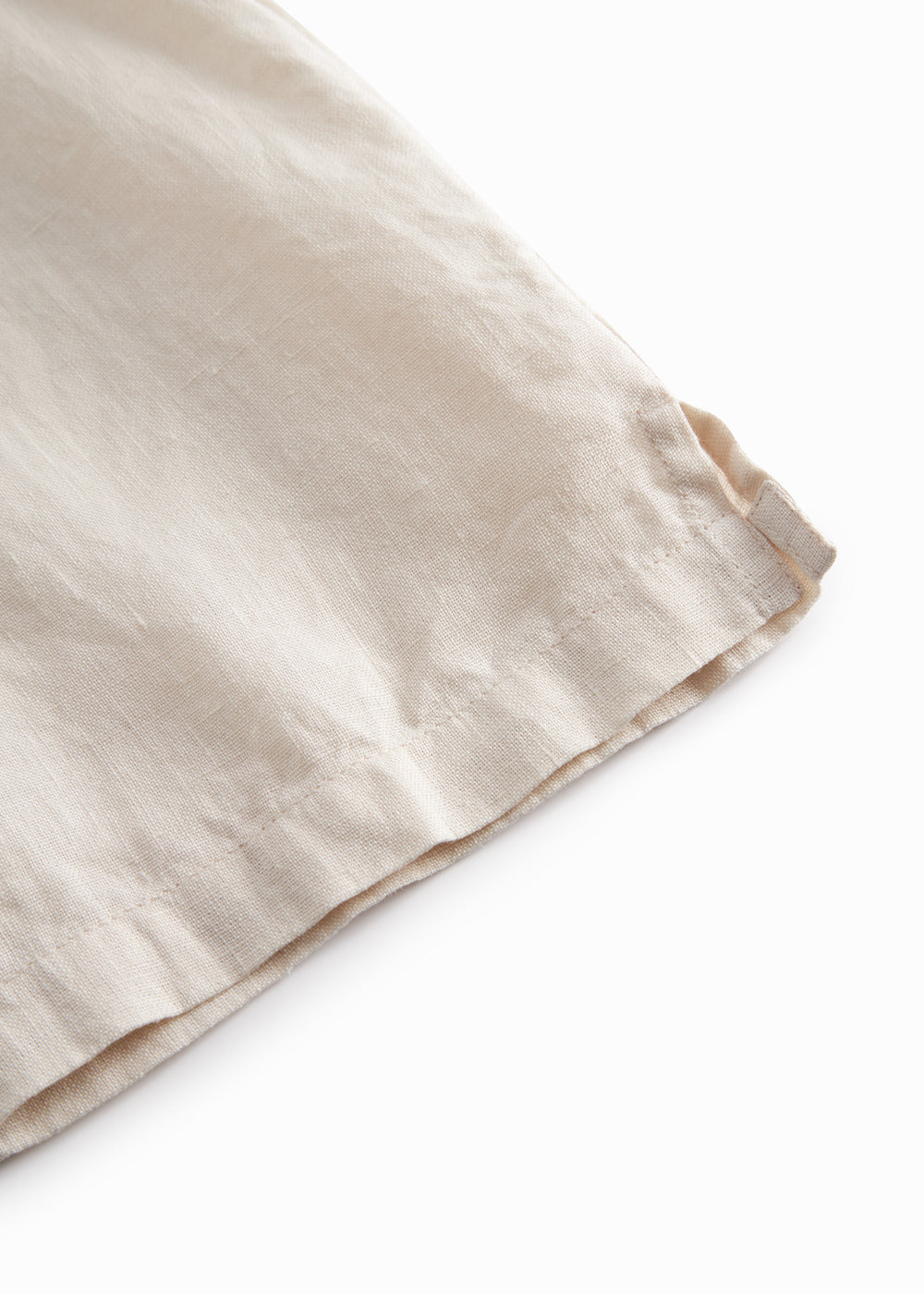 Sleeveless beige top for children with pleats.