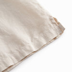 Sleeveless beige top for children with pleats.