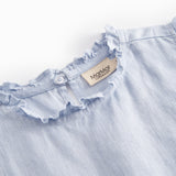 Ærmeløs lyseblå top til børn med flæsedetaljer