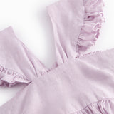 Ærmeløs lyserød kjole til børn med brede stropper og flæser på skulderen og smock bagpå