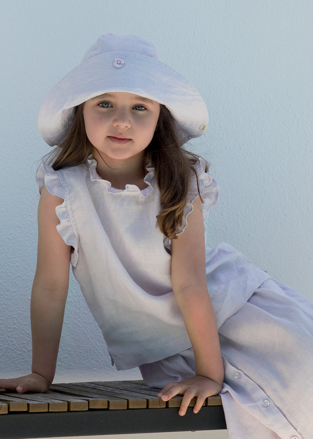 Child wearing a summer hat and a light dress