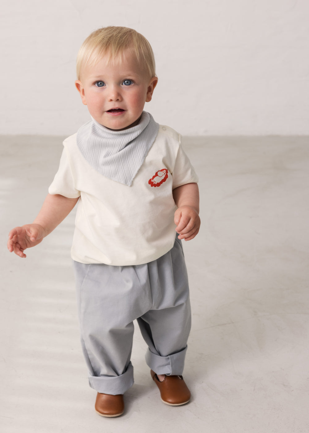 Child wearing blue chino pants and a white t-shirt.