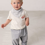 Child wearing blue chino pants and a white t-shirt.