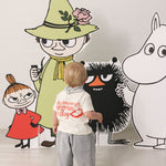 Children are dressed in light T-shirts and pants in front of Mumin figures.