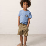 Child wearing a blue T-shirt and green shorts