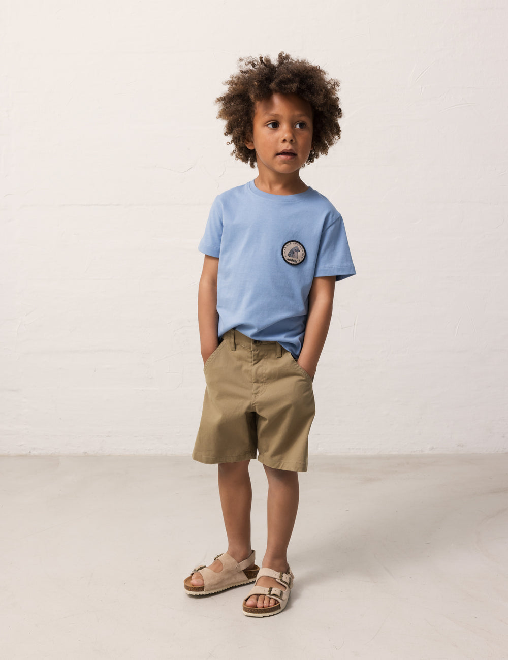 Child wearing a light blue T-shirt and khaki shorts