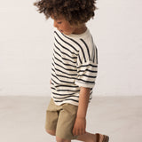 Children wearing a striped shirt and green shorts set from the side