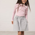 Wearing a long-sleeved t-shirt with bright red stripes and a blue canvas bottom.