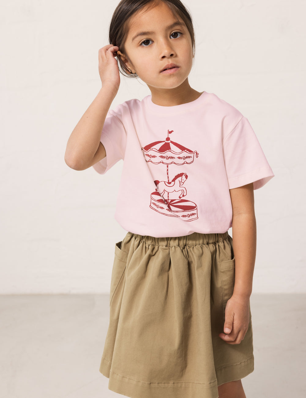 Children wearing a bright red T-shirt with a print and pants.