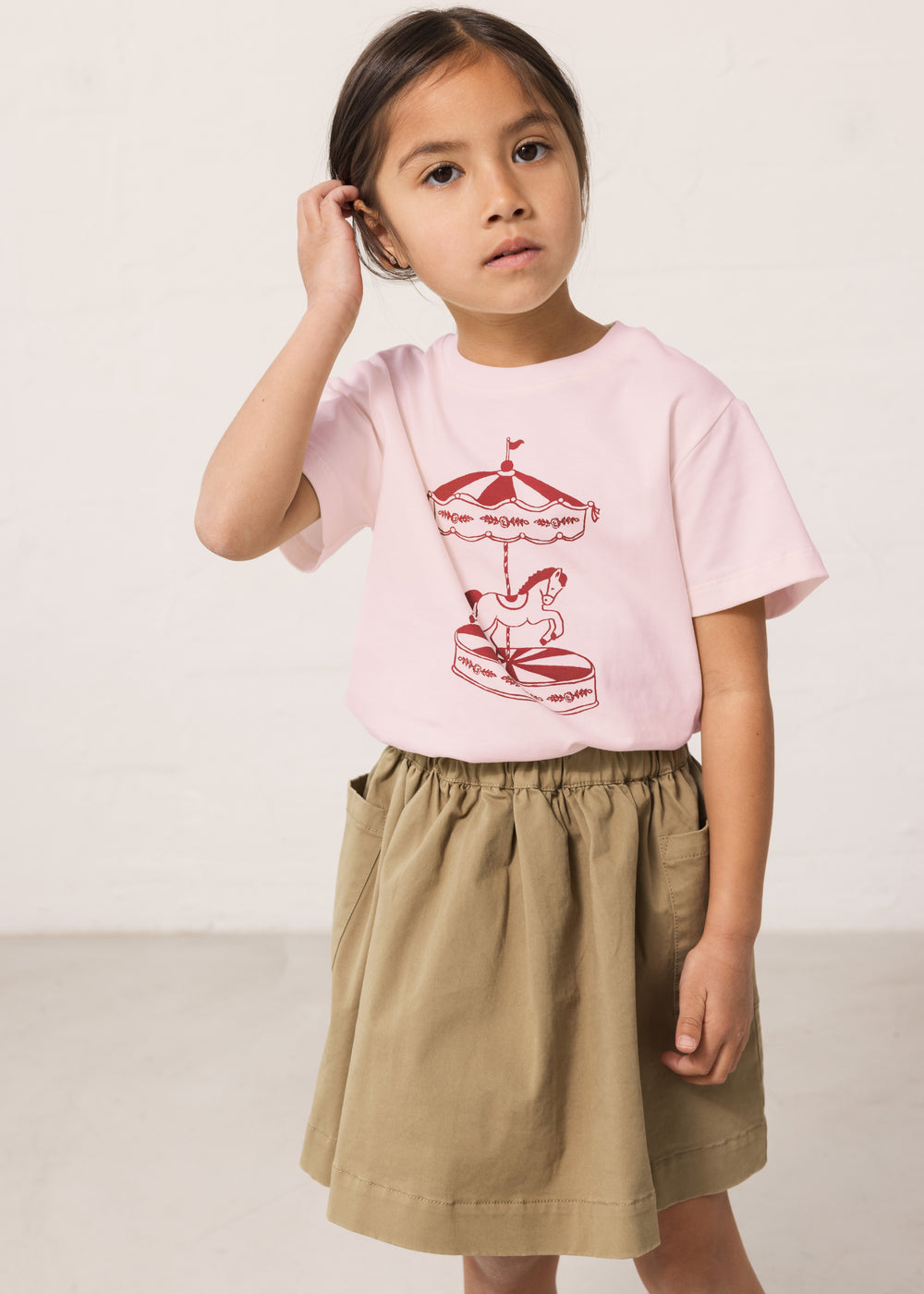 Children wearing a bright red T-shirt with a print and pants.