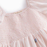 Lyserød kortærmet lagdelt kjole til børn med et fint blomster broderi, pufærmer og smockeffekt