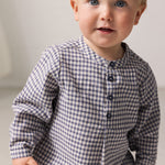 Baby wearing a long-sleeved turtleneck shirt with a collar and front closure.