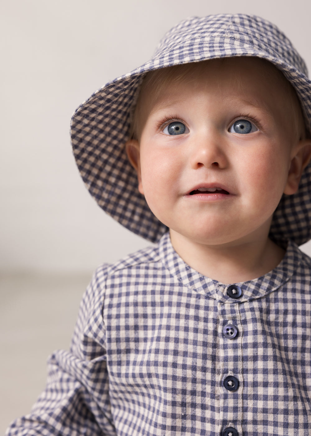 Baby wearing a long-sleeved turtleneck shirt and hat.