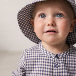 Baby wearing a long-sleeved turtleneck shirt and hat.